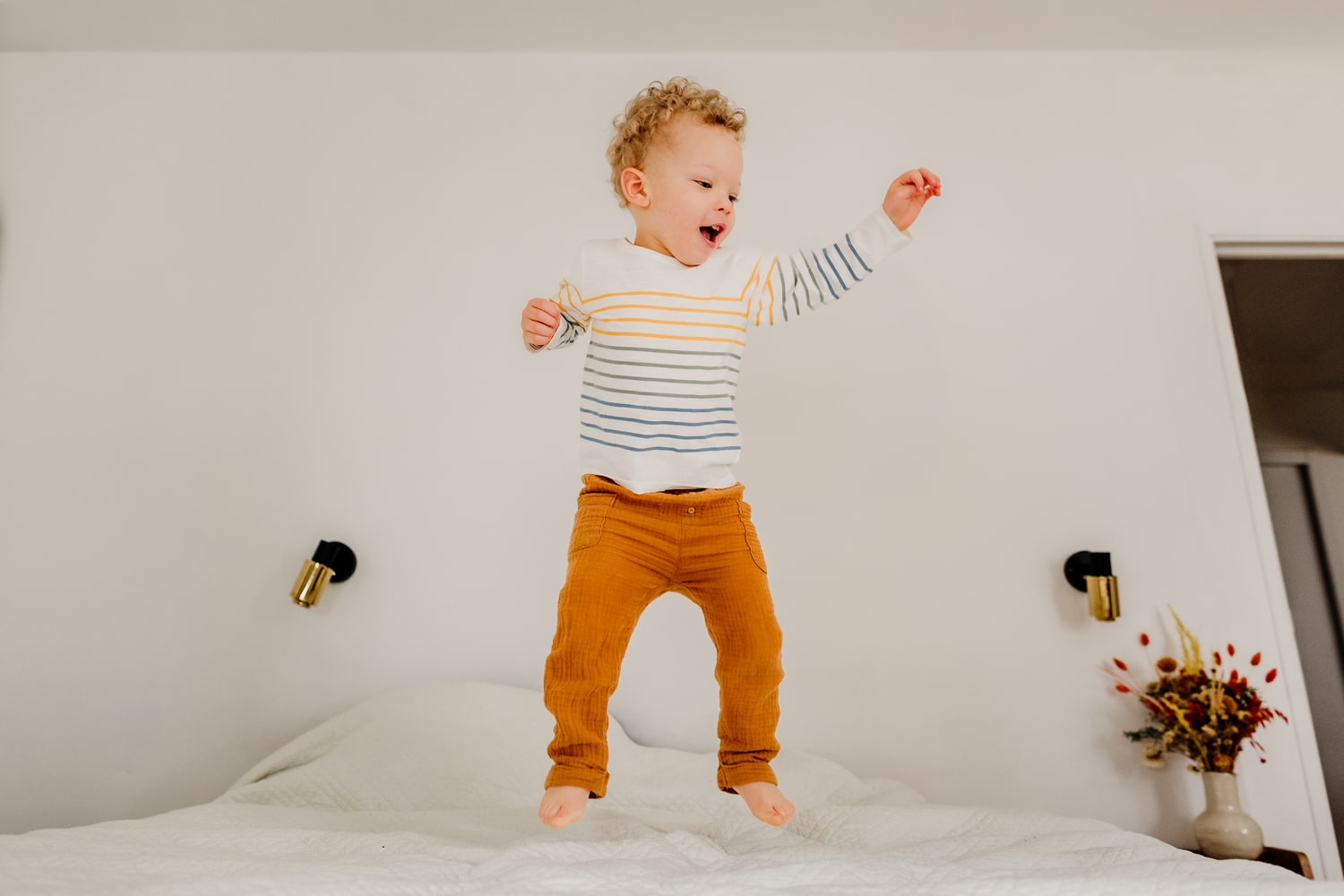 photographe famille paris enfant qui saute sur un lit et qui rigole a paris