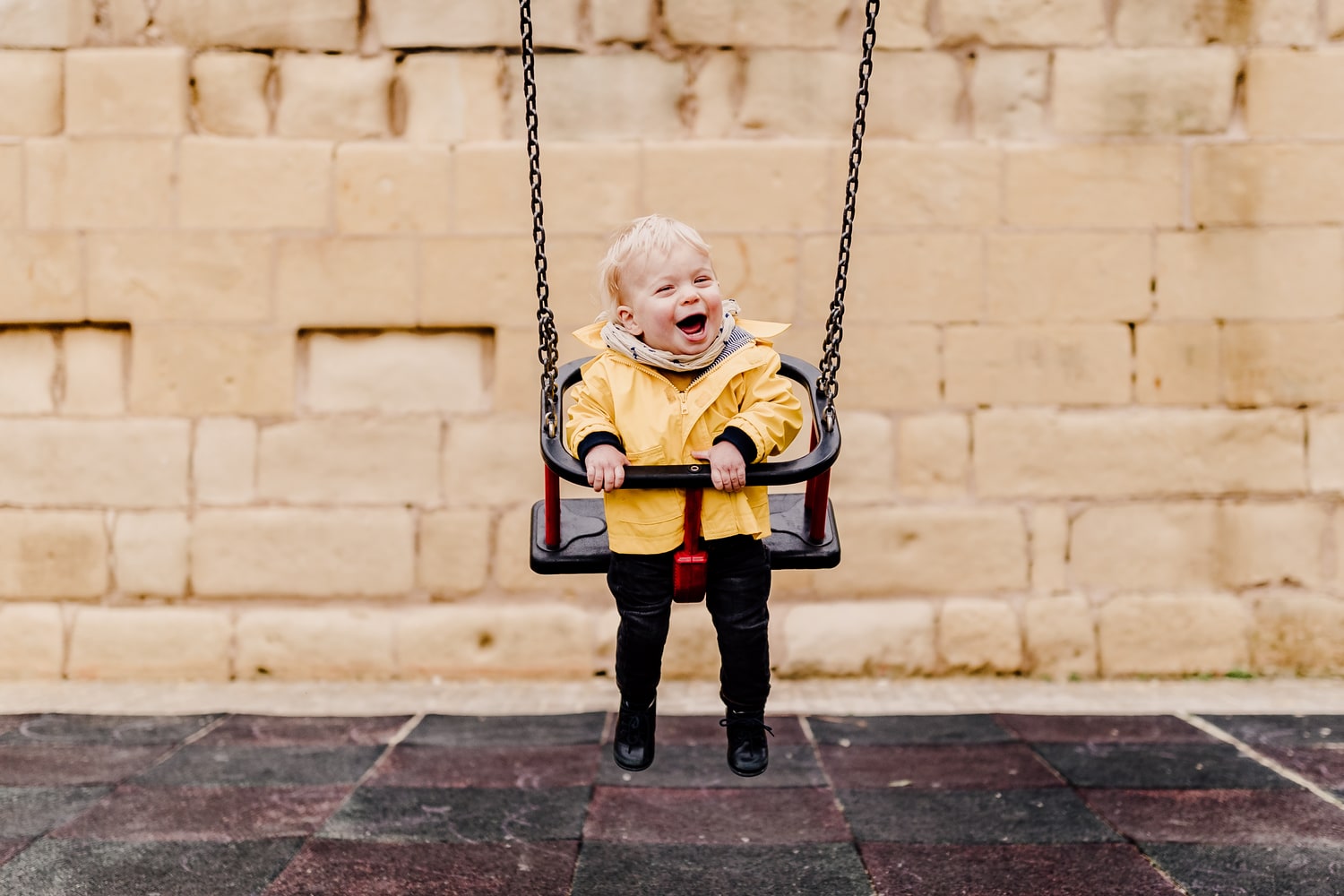 photo d un bebe heureux sur une balancoire dans un parc a paris